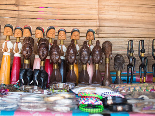 Thai souvenir shop with figures of animals and people on the background of bamboo boards