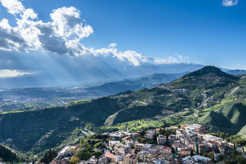 Fototapeta na wymiar View of the Taormina city and the active volcano Etna in the sunlights. Province of Messina.Sicily. Italy.