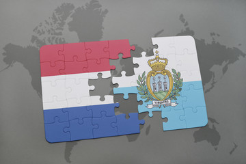 puzzle with the national flag of netherlands and san marino on a world map background.