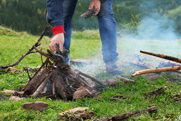 Man putting fireplace on mountain hill