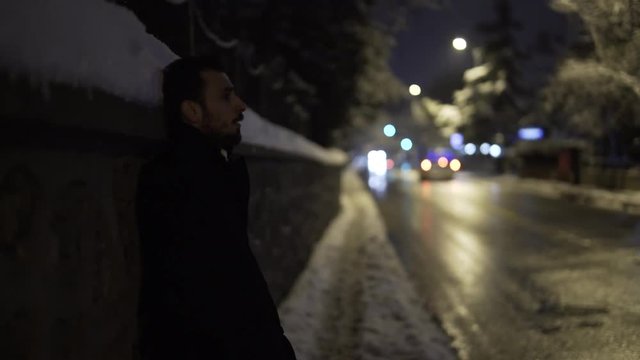 Young man crying on street. There is snow