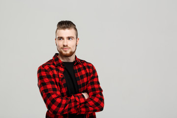 Young handsome man posing over grey background. Copy space.