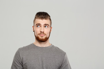 Young handsome man posing over grey background. Copy space. 