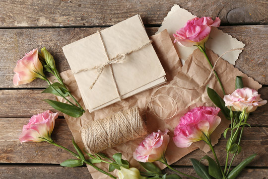 Beautiful flowers and gift card on wooden background