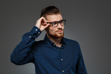 Fototapeta premium Young successful businessman posing over dark background. Copy space.