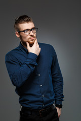 Fototapeta premium Young successful businessman posing over dark background. Copy space.