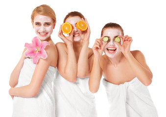 Three beautiful women wrapped in towels isolated on white