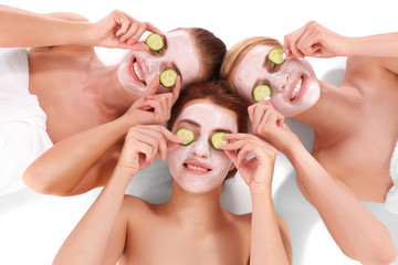 Young beautiful women relaxing with facial masks, top view