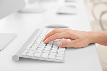 Woman typing on computer keyboard, closeup