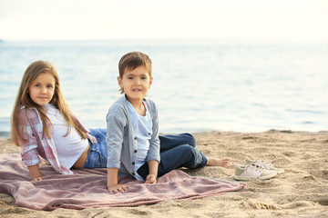 Fototapeta na wymiar Two cute kids relaxing on beach