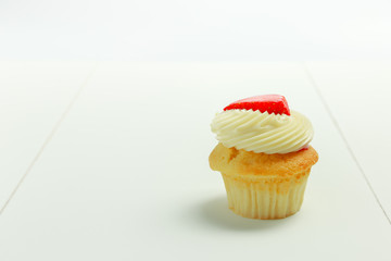 Vanilla Cupcake with strawberry on top on white table background