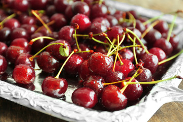 Old metal tray with ripe cherries, close up