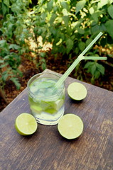 Nutritious detox water with lime and mint in a glass on the wood background
