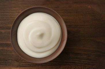 Bowl of fresh cream on wooden background