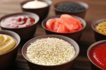 Fresh condiments and sauces on wooden background, closeup