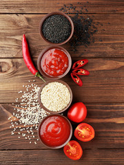 Fresh condiments and sauces on wooden background