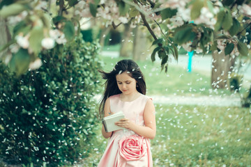 Girl in dress with notebook and pen in garden