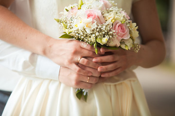 Obraz na płótnie Canvas groom and bride holding wedding bouquet