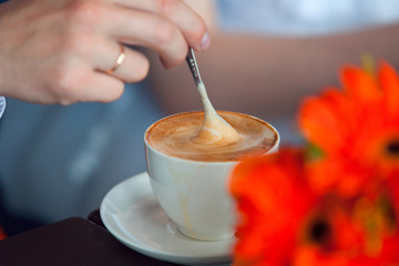 hands of the groom and the bride. coffee cups on the table