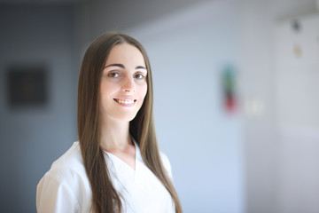 Portrait of young female doctor with charming white smile in clinic