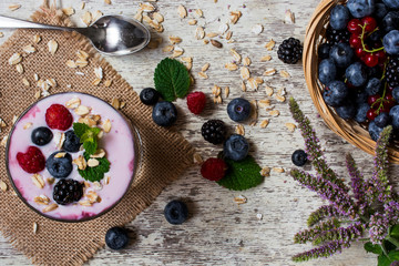 yogurt with berries, oat flakes and mint. top view