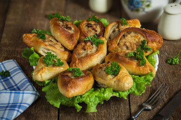 Baked open pies with fish filling on lettuce leaves