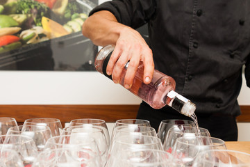 waiter pouring gin in a glass