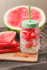 Watermelon Drink in Glass with Slices on Wooden Background