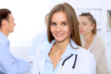 Fototapeta premium Happy doctor woman with medical staff at the hospital sitting at the table and discussing medical history
