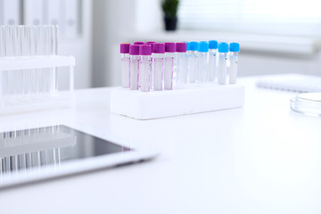 Research laboratory working space. Test tubes and tablet PC are lying at the table. Medical equipment. Blood test