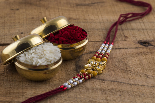 A Rakhi with rice grains and kumkum. An Indian festival Raksha Bandhan background.