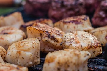 Delicious sizzling sea scallops grilling on a charcoal hibachi grill 