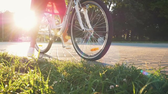 Young attractive girl sitting on vintage bike in park at the morning, dolly shot