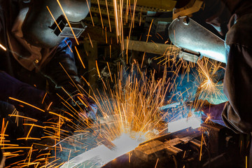 Team welding in factory