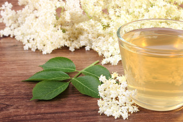 Fresh healthy juice and elderberry flowers on rustic board