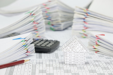 House and brown pencil with blur pile paperwork as background