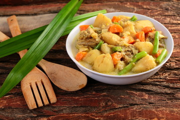 Rich hearty beef stew ready to serve.on wooden background.