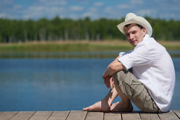Man resting on nature while sitting on the pier