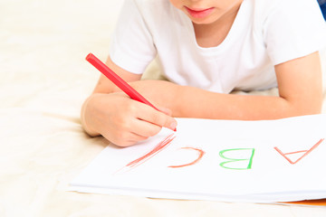 Obraz na płótnie Canvas little boy learning to write letters