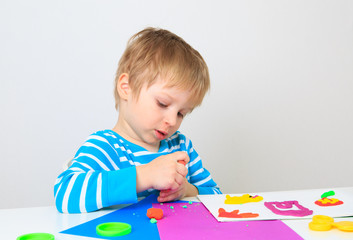 little boy playing with clay dough, education and daycare
