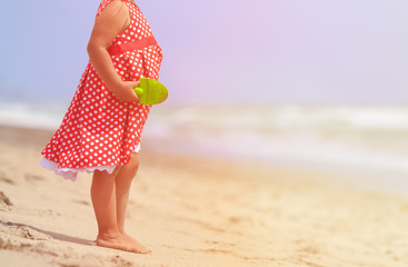 little girl play with sand on beach