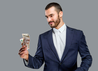 Bearded male in a suit holding cash.