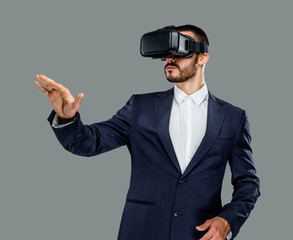 Male in a suit with virtual reality glasses on his head.