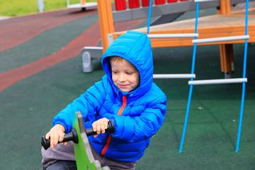 Obraz premium child having fun at playground riding on the spring horse