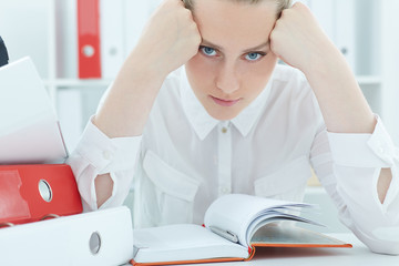 Portrait of a tired businesswoman looking at the camera  propped head in his hands.