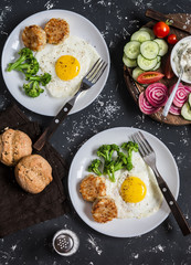 Fried eggs, chicken meatballs, vegetables, and yogurt sauce on a dark background. Healthy lunch or snack