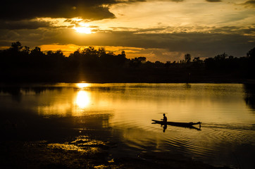 Fototapeta premium Silhouette of a man rowing in the canoe.