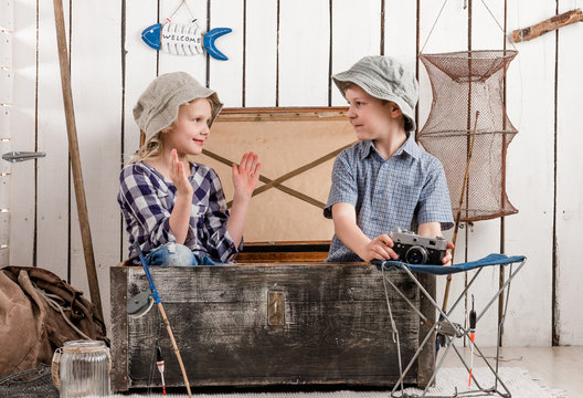 little boy and girl talk sitting in big old chest