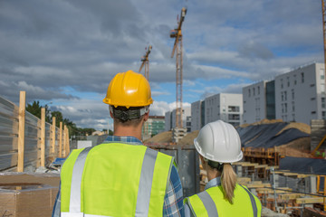 business, building, paperwork and people concept - builder in hardhat with tablett outdoors