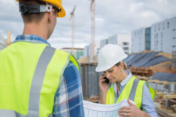 View of a Engineer and worker checking plan on construction site